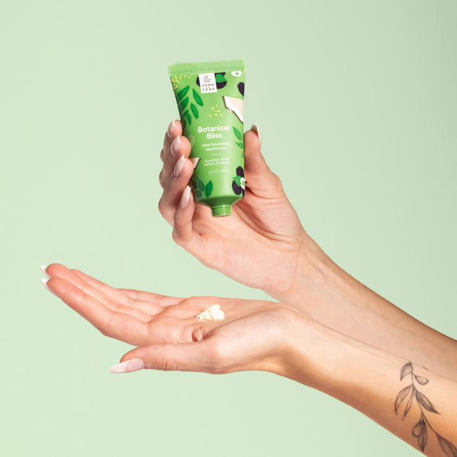 Hand pouring Botanical Bliss hand cream from one hand to the other
