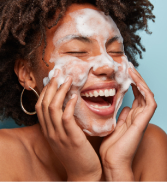 Woman washing her face to treat breakouts