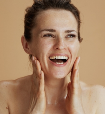 Woman applying moisturizer to her cheek